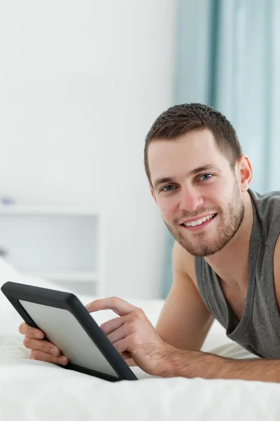 Portret mężczyzny atrakcyjnego przy użyciu komputera typu tablet podczas lyin — Zdjęcie stockowe