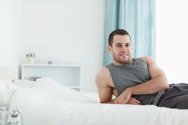 Человек позирует на своей кровати — стоковое фото