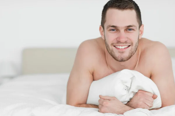 Sonriente hombre acostado sobre su vientre — Foto de Stock
