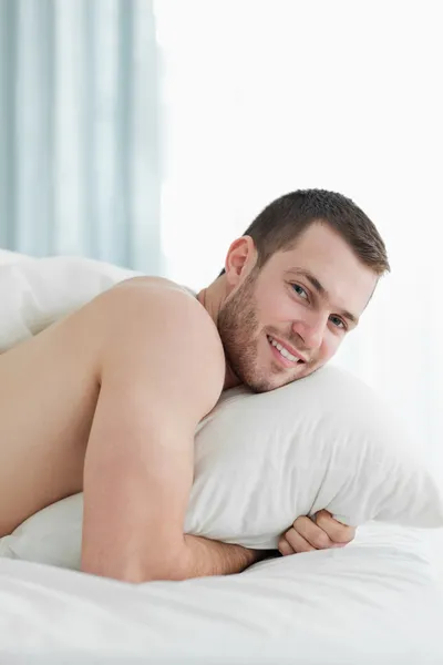 Портрет улыбающегося молодого человека, лежащего на животе — стоковое фото