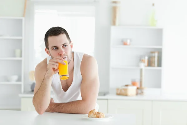 Fiatal férfi ivás narancslé — Stock Fotó
