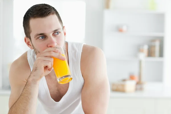 Przystojny mężczyzna pije sok pomarańczowy — Zdjęcie stockowe
