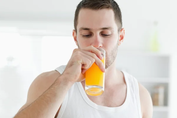 Homem atraente bebendo suco de laranja — Fotografia de Stock