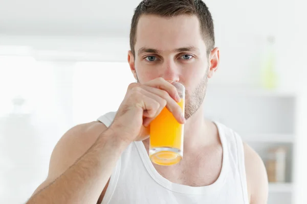 Spokojny człowiek pije sok pomarańczowy — Zdjęcie stockowe