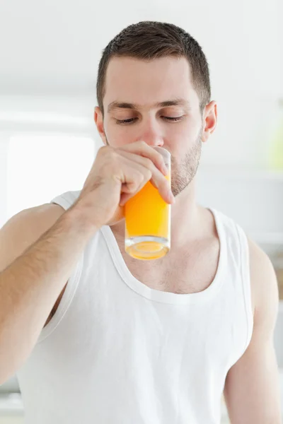 Retrato de um homem atraente bebendo suco de laranja — Fotografia de Stock