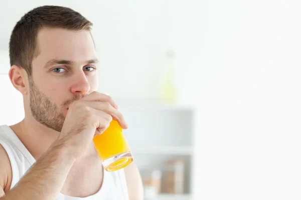 Портрет красивого мужчины, пьющего апельсиновый сок — стоковое фото