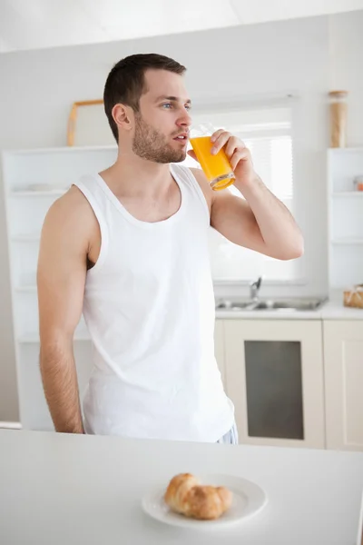 Portrait of a healthy man drinking orange juice — Stock Photo, Image