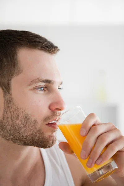 Człowiek pije sok pomarańczowy z bliska — Zdjęcie stockowe