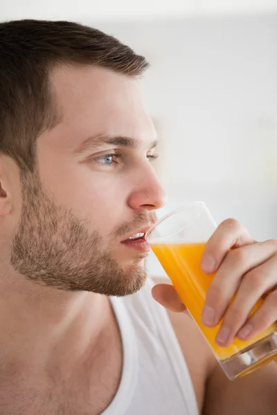Bliska młodego człowieka do picia sok pomarańczowy — Zdjęcie stockowe