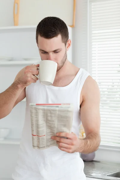 Retrato de um homem bebendo chá enquanto lia as notícias — Fotografia de Stock