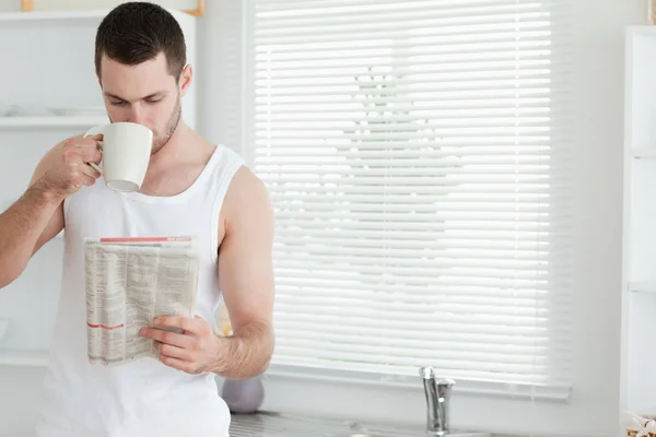 Uomo che beve il tè mentre legge le notizie — Foto Stock