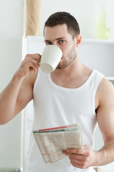 Ritratto di un bell'uomo che beve tè mentre legge le notizie — Foto Stock