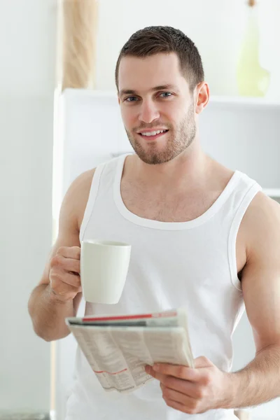 Portret mężczyzny uśmiechający się picia kawy podczas czytania wiadomości — Zdjęcie stockowe