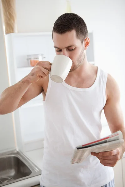 Портрет улыбающегося мужчины, пьющего чай во время чтения новостей — стоковое фото