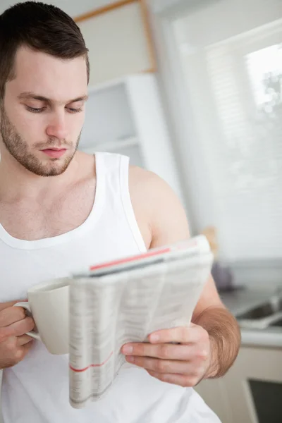 Porträtt av en man som dricker apelsinjuice samtidigt läsa nyheter — Stockfoto