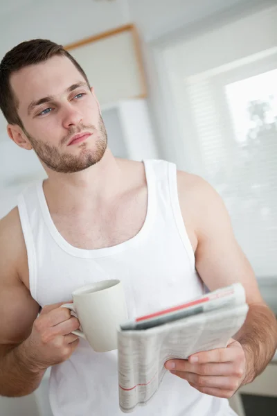 Portrait of a serious man drinking orange juice while reading th — Stock Photo, Image
