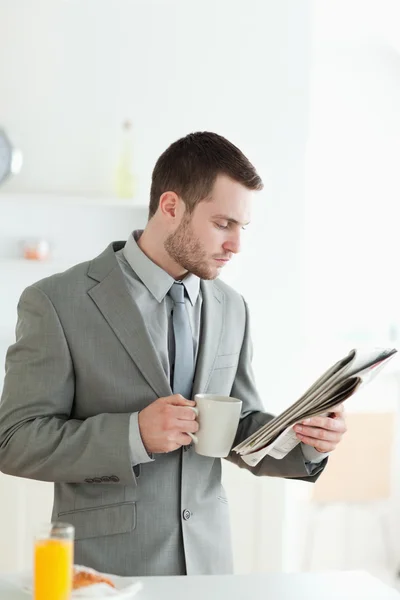 Portrait of a handsome businessman having breakfast while readin — Stock Photo, Image