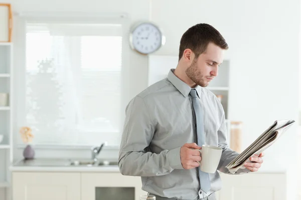Fiatal üzletember olvasni a híreket, a reggeli elfogyasztása közben — Stock Fotó