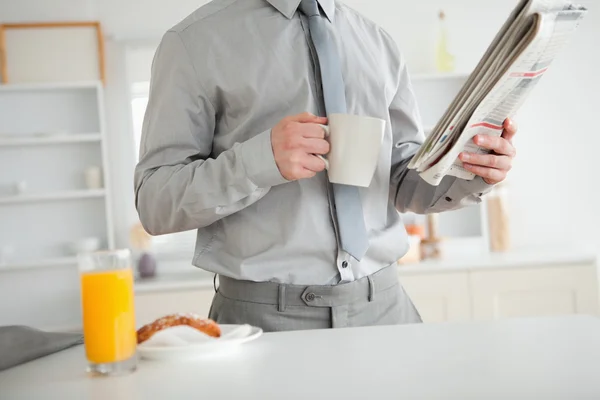 Biznesmen trzymając gazetę przy śniadaniu — Zdjęcie stockowe