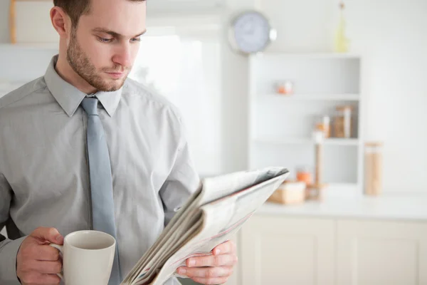 Geschäftsmann liest Zeitung beim Teetrinken — Stockfoto