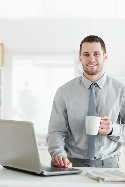 Porträtt av en affärsman som använder en bärbar dator när man dricker kaffe — Stockfoto