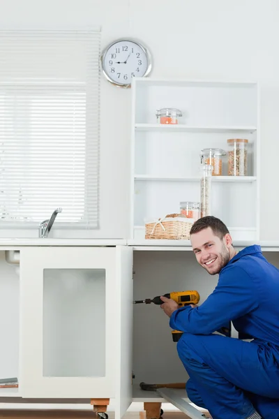 Portrait of a smiling handyman fixing a door — Stock Photo, Image