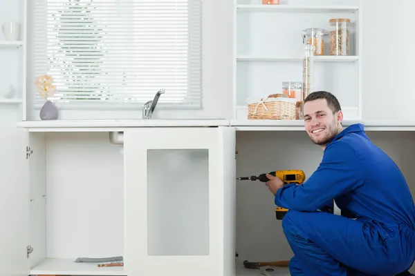 Happy handyman fixing a door — Stock Photo, Image
