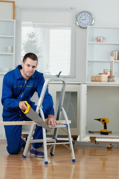 Portrait of a handyman cutting a wooden board — Stock Photo, Image