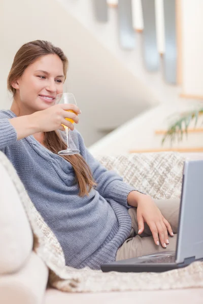 Portrait of a woman having a glass of wine during a video confer — Stock Photo, Image