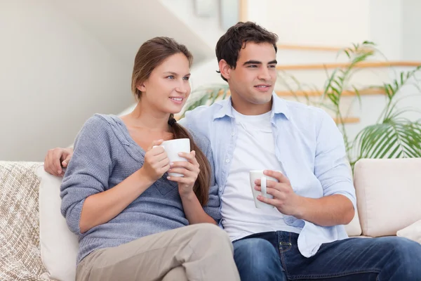 Пара смотрит телевизор за чашкой чая — стоковое фото