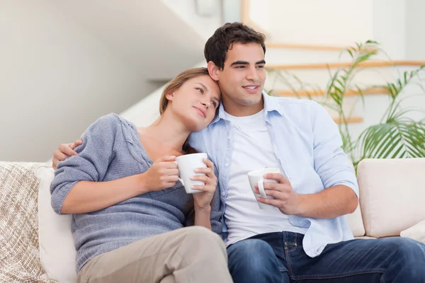 Preciosa pareja viendo la televisión mientras bebe té —  Fotos de Stock