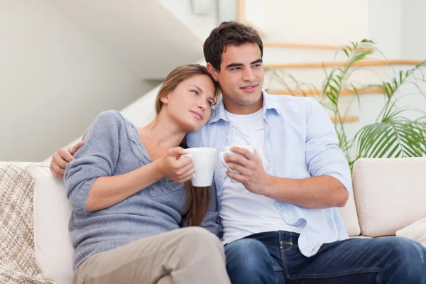 Piękna para oglądania telewizji podczas picia kawy — Zdjęcie stockowe