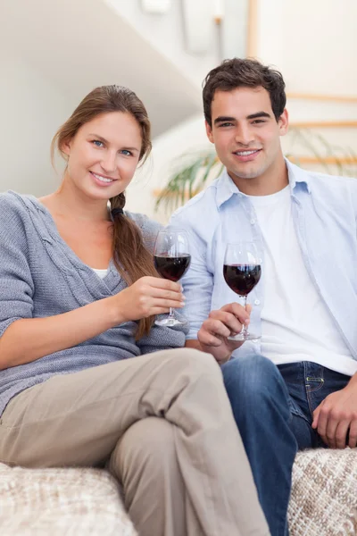 Retrato de um jovem casal tomando um copo de vinho tinto — Fotografia de Stock
