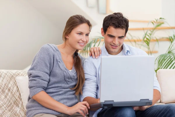 Χαμογελώντας ζευγάρι χρησιμοποιώντας ένα φορητό υπολογιστή — Φωτογραφία Αρχείου