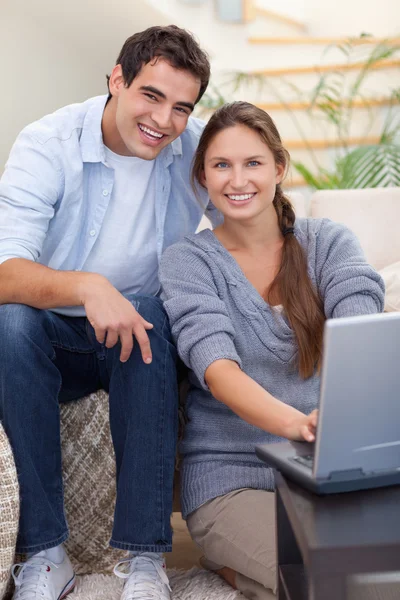 Porträtt av en strålande par som använder en bärbar dator — Stockfoto