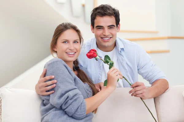 Молодой человек предлагает своей жене розу — стоковое фото