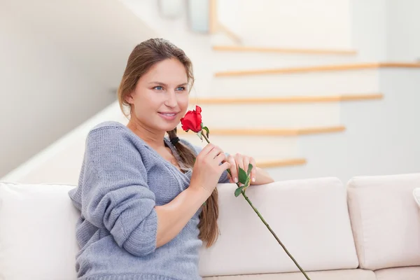 Junge Frau, die eine Rose riecht — Stockfoto