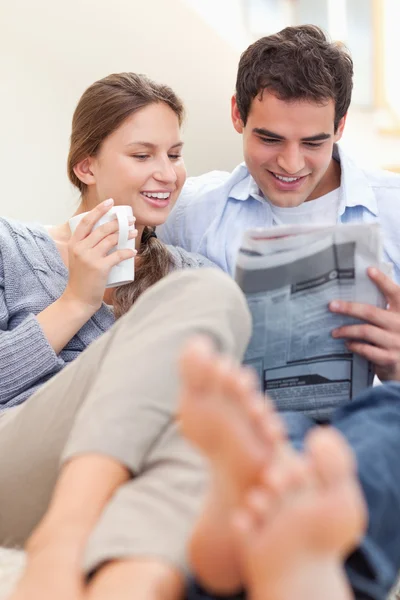Retrato de um casal feliz lendo um jornal pela manhã — Fotografia de Stock