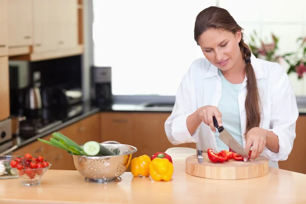 Young woman slicing a pepper — Stock Photo, Image