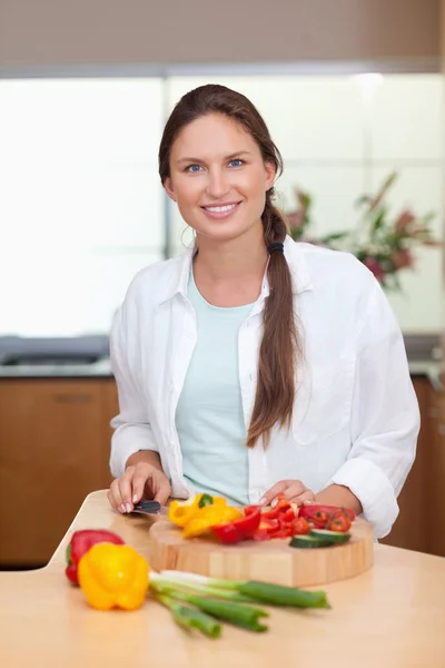 Portrait of a lovely woman slicing a pepper — Stock Photo, Image