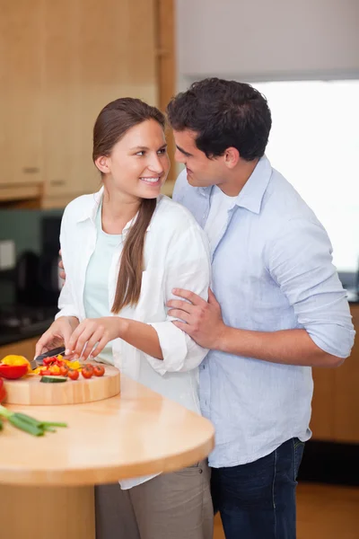 Porträtt av en man kramar sin fru medan hon matlagning — Stockfoto
