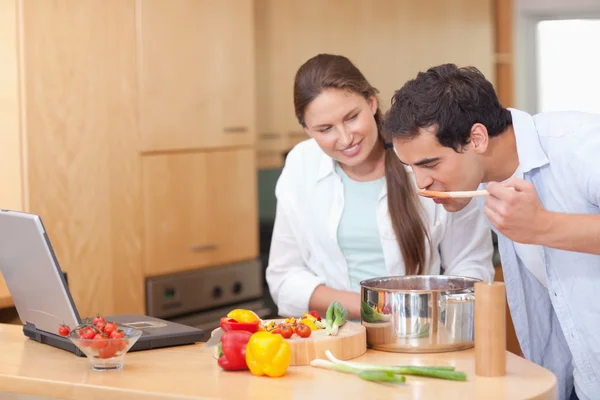 Gourmet couple using a laptop to cook — Stock Photo, Image