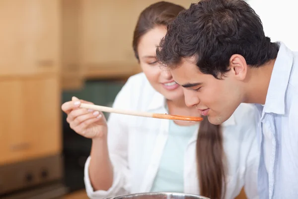 Człowiek próbuje jego żona sos z bliska — Zdjęcie stockowe