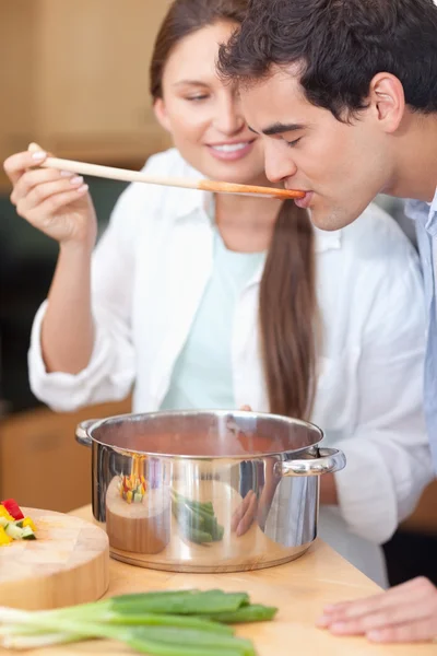 Portrait of a young man trying his wife's sauce — Stock Photo, Image