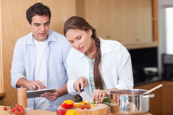 Modern couple using a tablet computer to cook — Stock Photo, Image