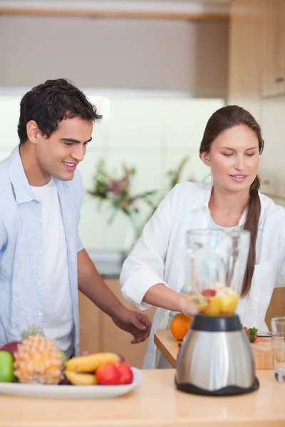Portrait of a young couple making fresh fruits juice — Stock Photo, Image