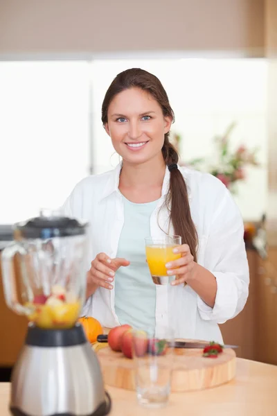 Retrato de una mujer bebiendo jugo de frutas frescas — Foto de Stock