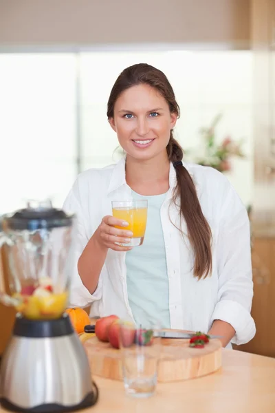 Porträt einer jungen Frau, die frischen Fruchtsaft trinkt — Stockfoto