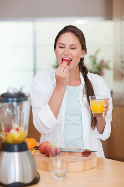 Retrato de una mujer comiendo una fresa fresca —  Fotos de Stock