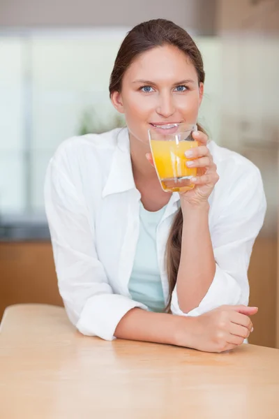 Porträtt av en leende kvinna som dricker juice — Stockfoto